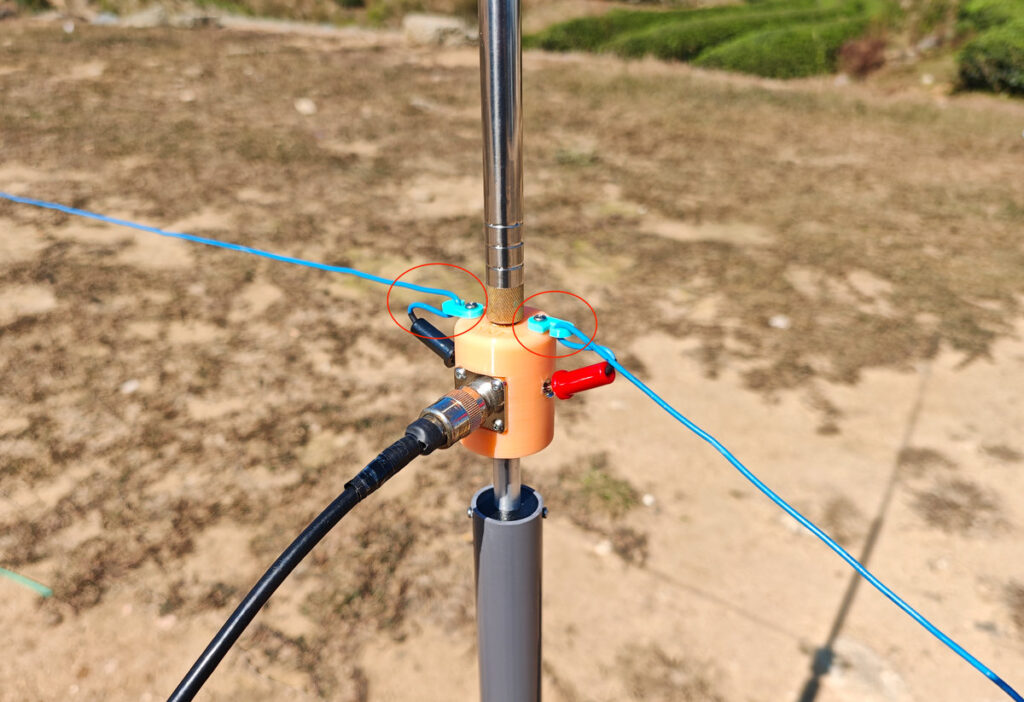 Antenna base hooks preventing banana plug from slipping out of socket