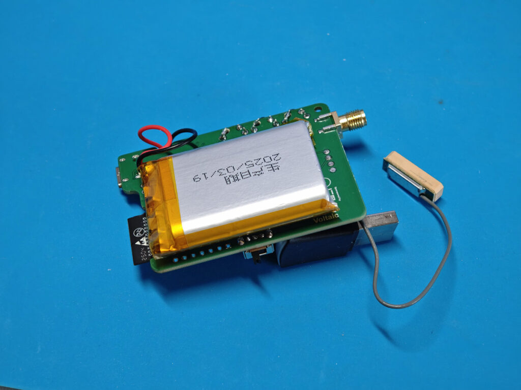 Fully assembled custom Icarus‑v2 Meshtastic node board with battery at back
