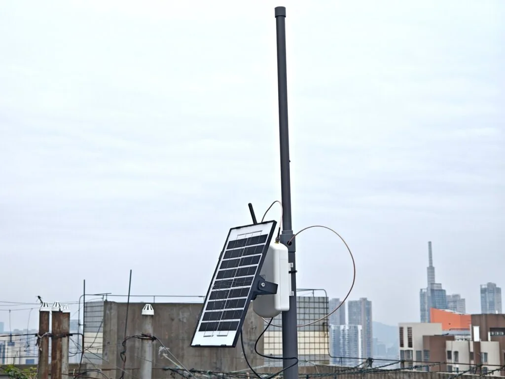 Rooftop Meshtastic base station with homemade PVC J-Pole antenna and city skyline
