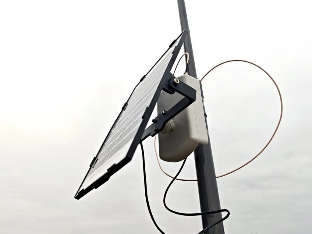 Solar-powered Meshtastic node with copper cable loop and rooftop J-Pole antenna setup