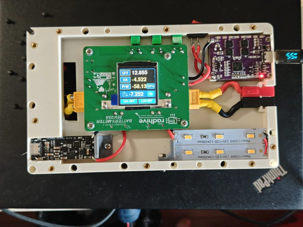 Open field battery enclosure showing the battery meter board installed between a 4S LiFePO4 pack and the output wiring.