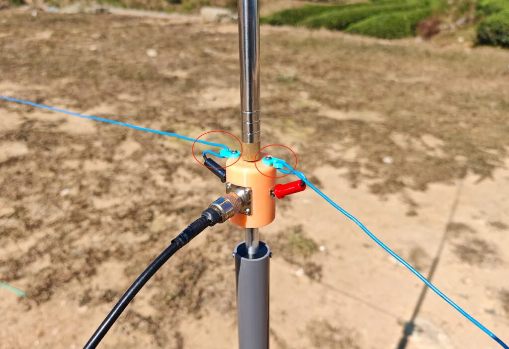 Antenna base hooks preventing banana plug from slipping out of socket